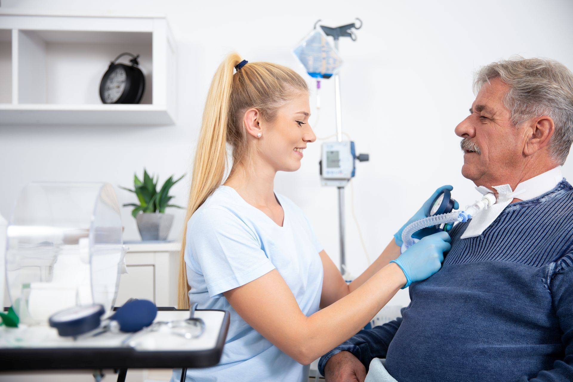 Pflegekraft versorgt tracheotomierten Patienten