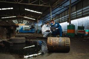 Gefährliche Chemikalien in Fabriken. Teams von Arbeitern mit Schutzanzügen und Gasmasken hantieren in einer Fabrik mit gefährlichen Chemikalien.