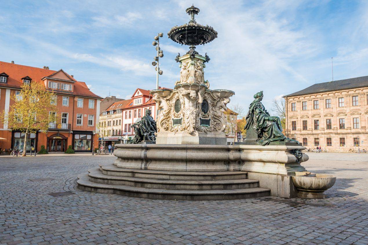 Blick auf den Hugenottenbrunnen am Schlossplatz in Erlangen – zentrale Lage nahe Hausarzt in Erlangen