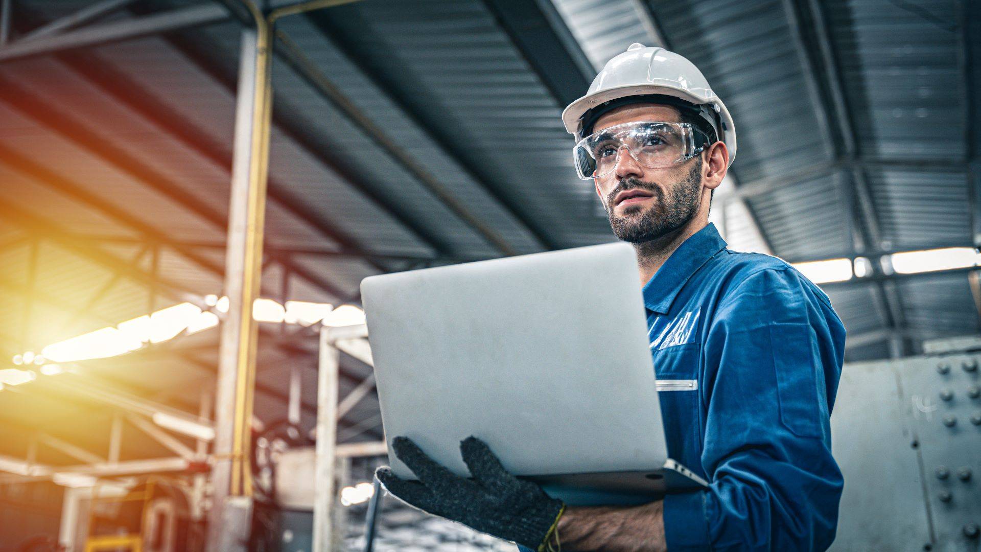 Techniker mit Laptop in Industriehalle