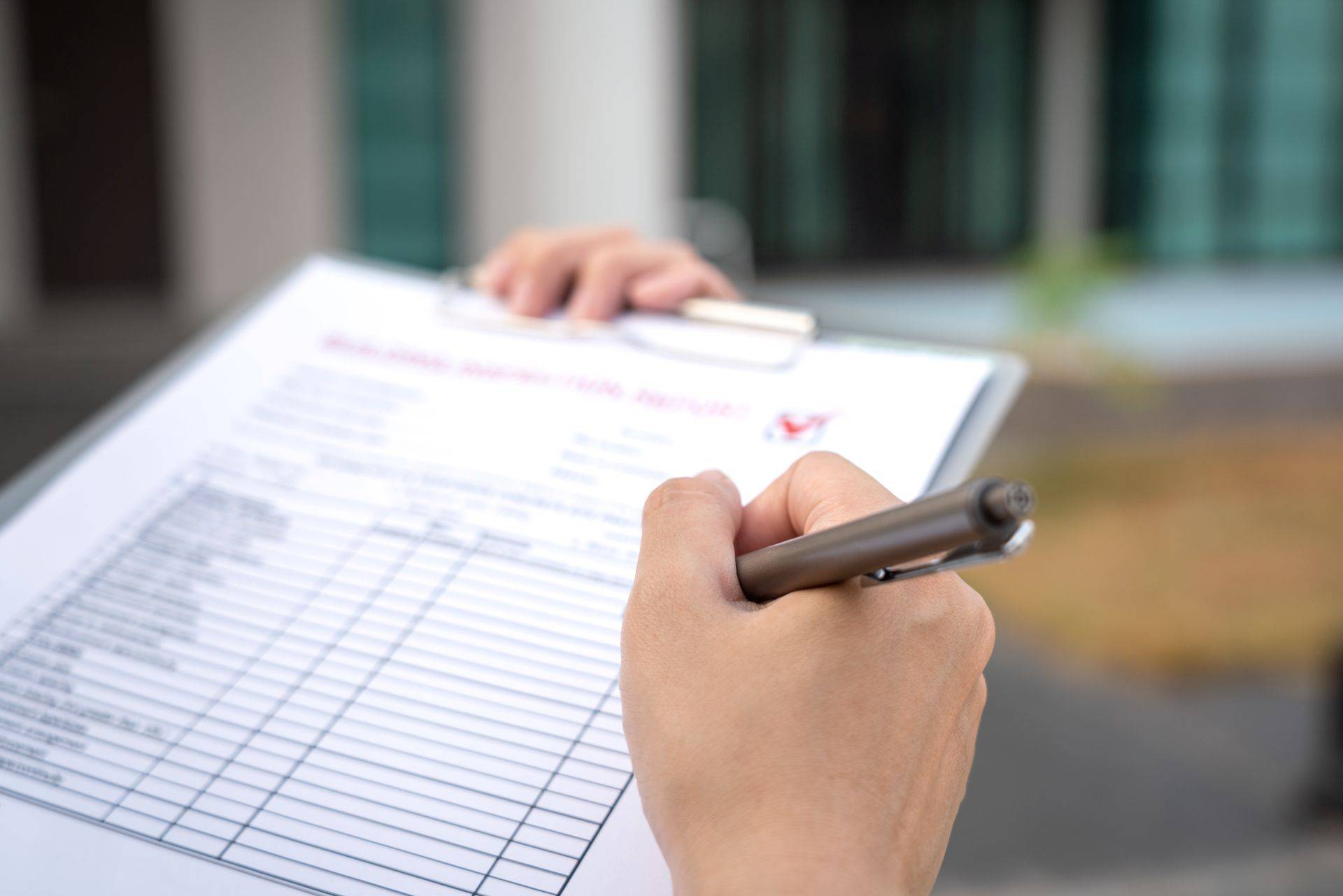 Hand füllt technische Checkliste auf Klemmbrett aus – verdeutlicht Sicherheitsprüfung und Qualitätssicherung bei der Montage